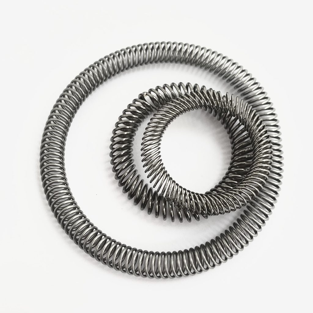 Compression Canted Coil Springs for Seals and Other Applications