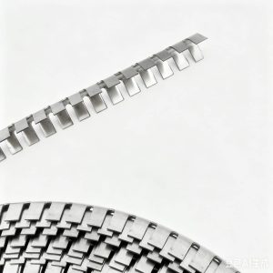 Close-up of a curved metal strip with repeating rectangular tabs along its edge on a light background.